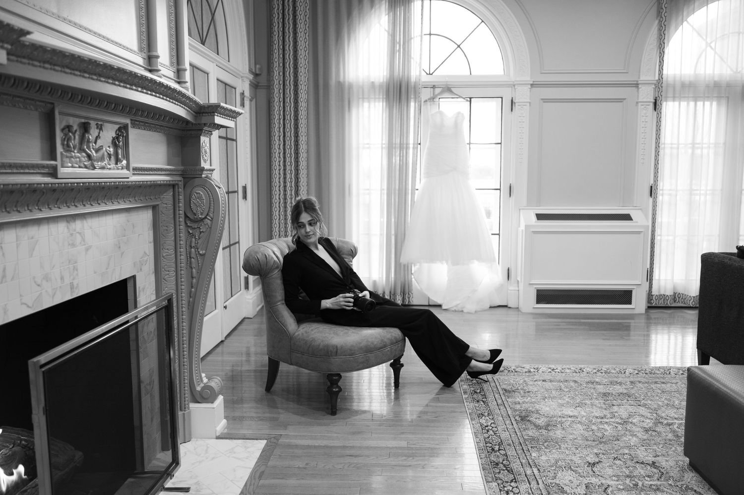 Interior hallway of an elegant venue with arched windows and natural light.
