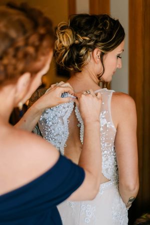 Close-up of intricate lace and beadwork details on the back of a wedding dress.