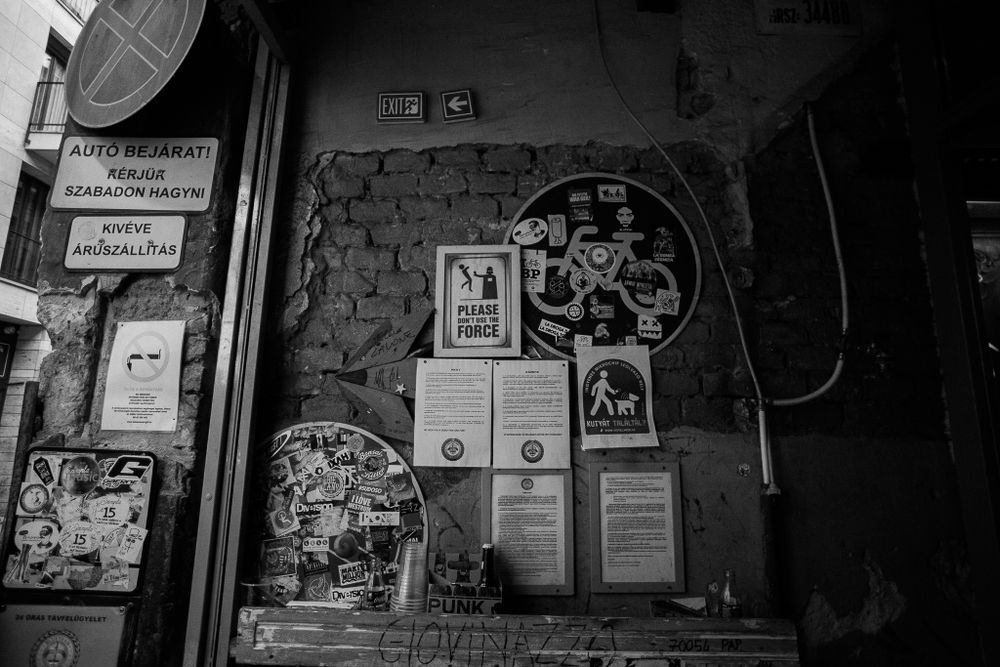 Vintage posters and notices on a weathered wall with circular decorative elements.
