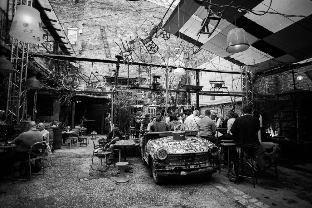 A gritty auto repair shop with vintage cars and industrial equipment in black and white.