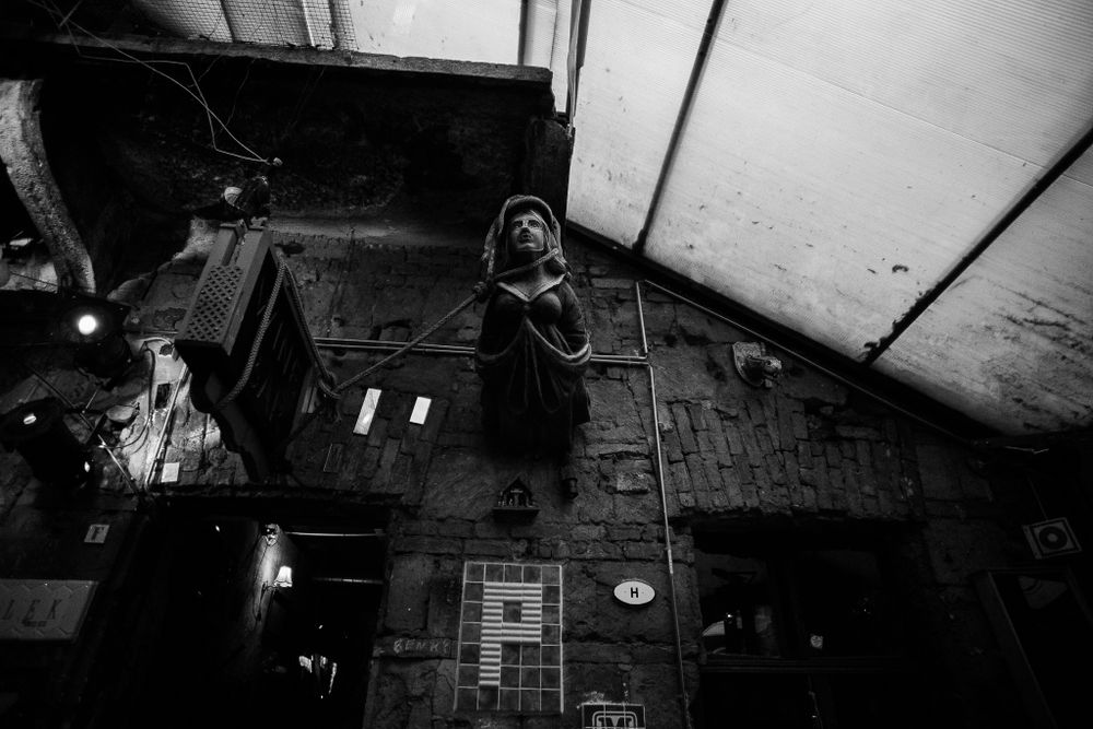 Dark moody interior shot of an industrial space with textured flooring and dramatic shadows.