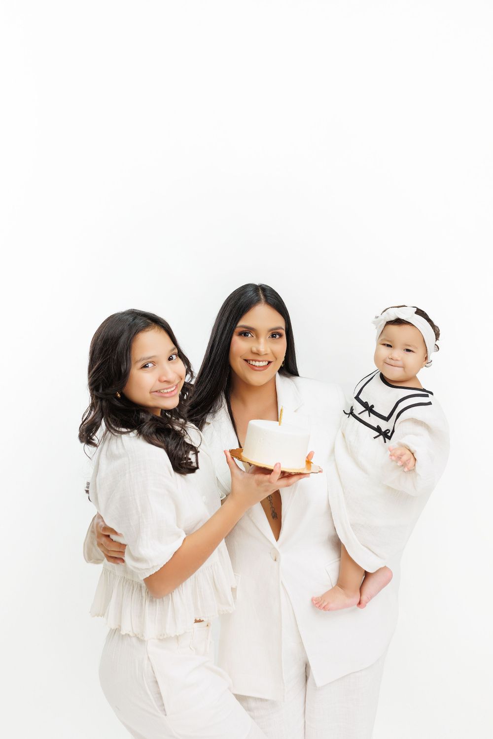Studio family photo session with everyone dressed in coordinating white outfits.