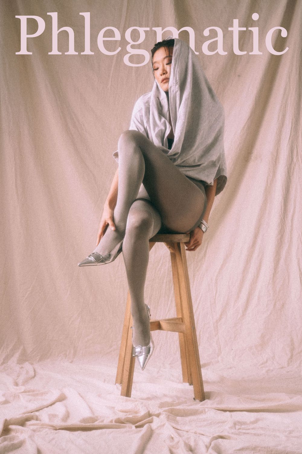 Artistic portrait featuring draped fabric on wooden stool with 'Phlegmatic' text overlay.