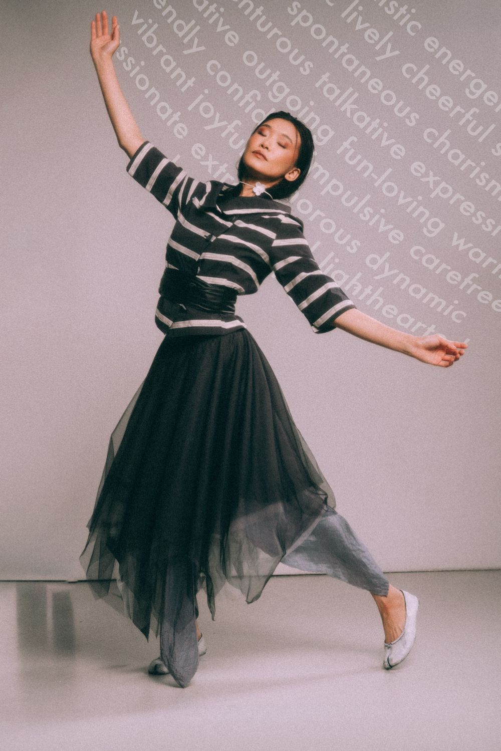 Dancer in striped top and tulle skirt poses gracefully against text background.