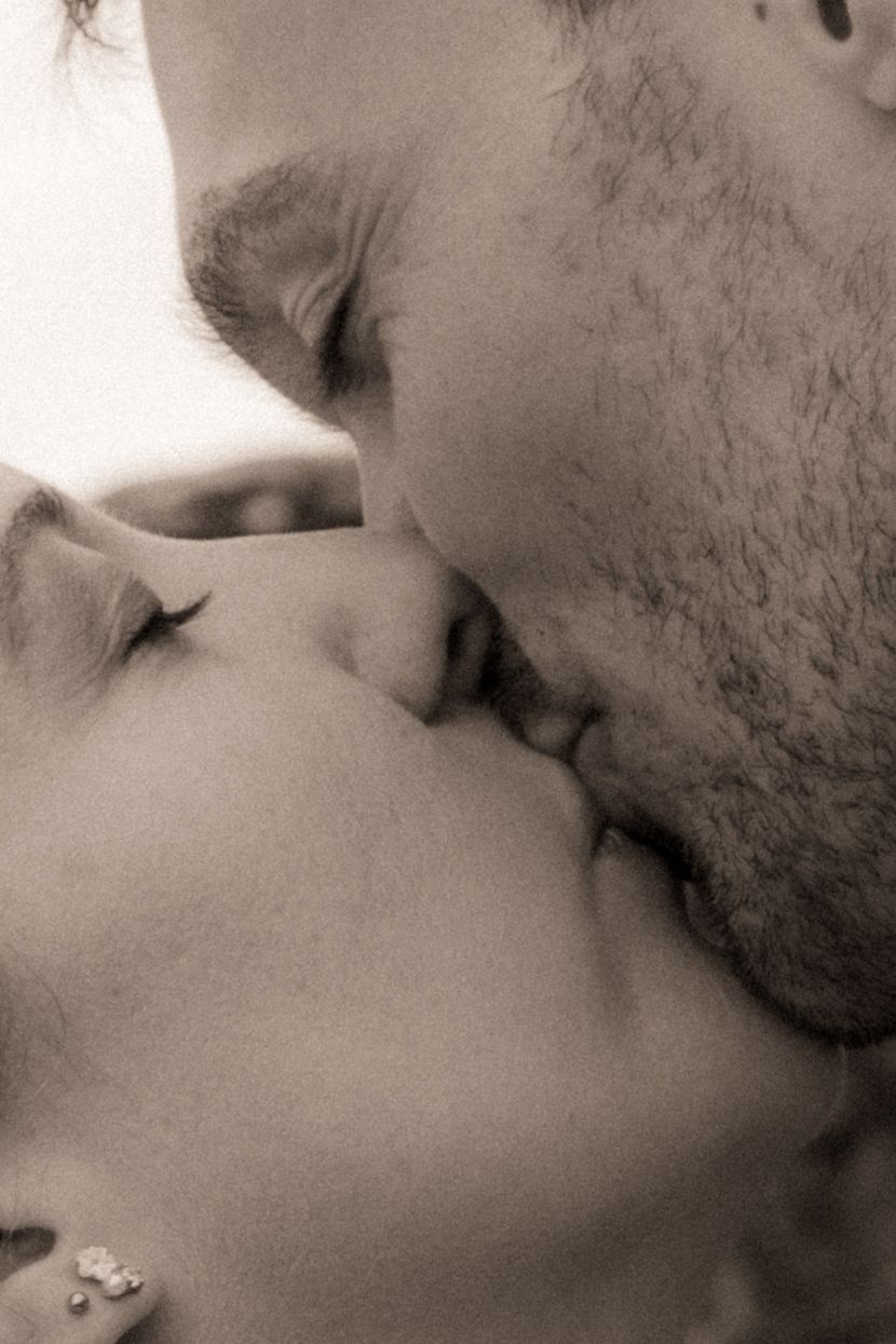 A series of intimate sepia-toned close-up shots showing tender moments between two people engaged in romantic kisses.