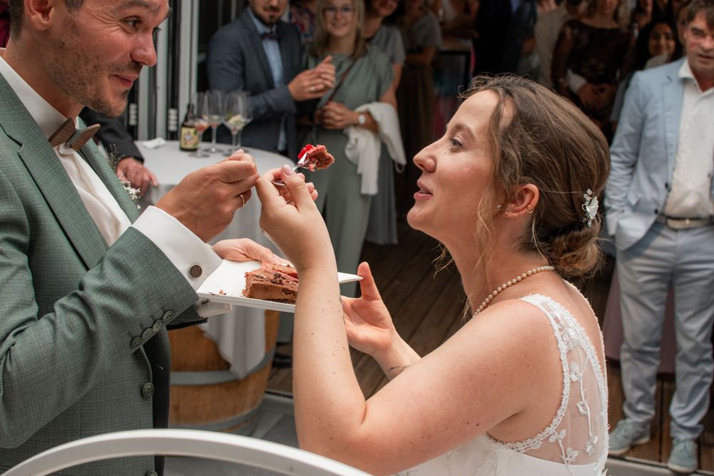 Couple celebrating at outdoor wedding reception while sharing a drink together.