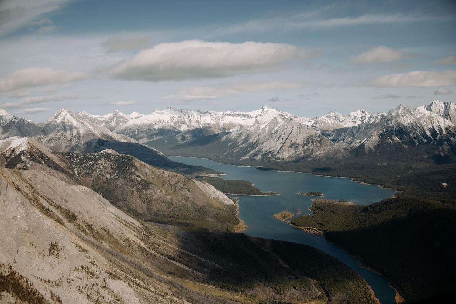 Scenic mountain landscape with snow-capped peaks overlooking a blue lake.