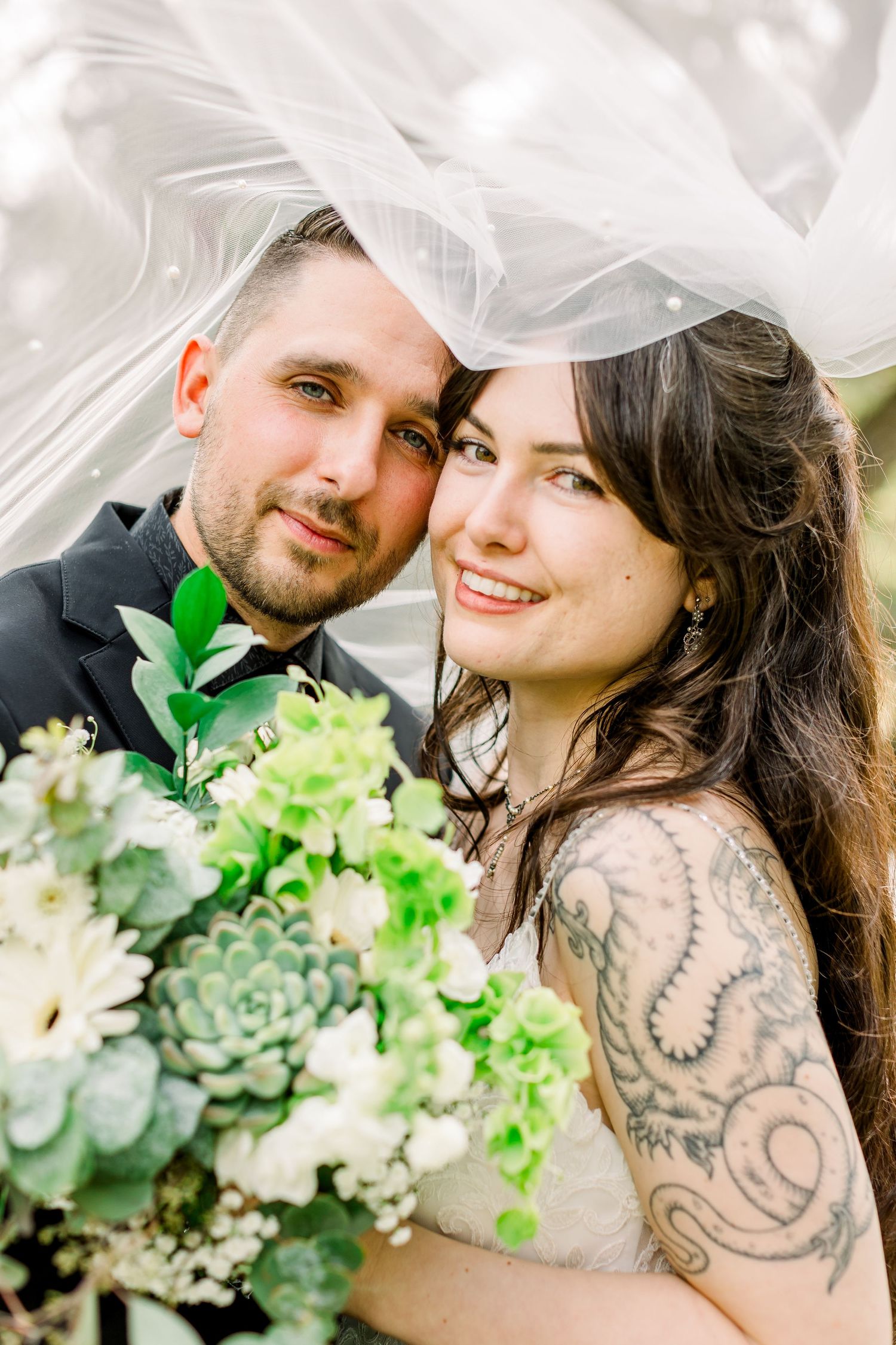 A vintage backyard wedding in Santa Cruz, CA. Bride with tattoos. Bride and Groom photos with veil.