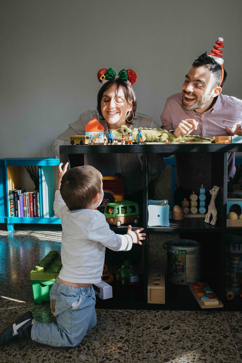 A sequence of photos showing a child and adult playing peek-a-boo together in a dimly lit room with bookshelves.