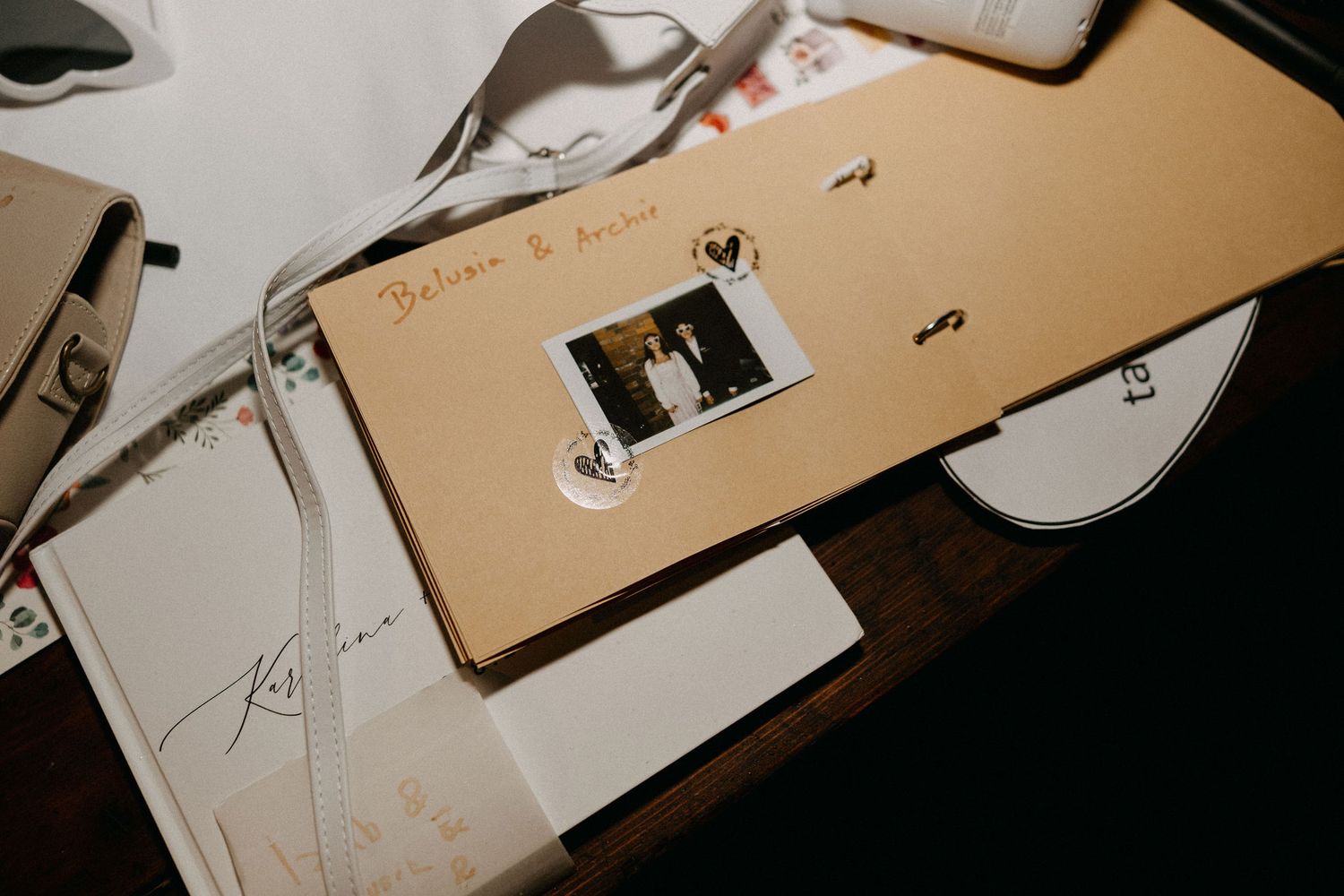 Vintage photo album and wedding memorabilia arranged on dark wooden surface.