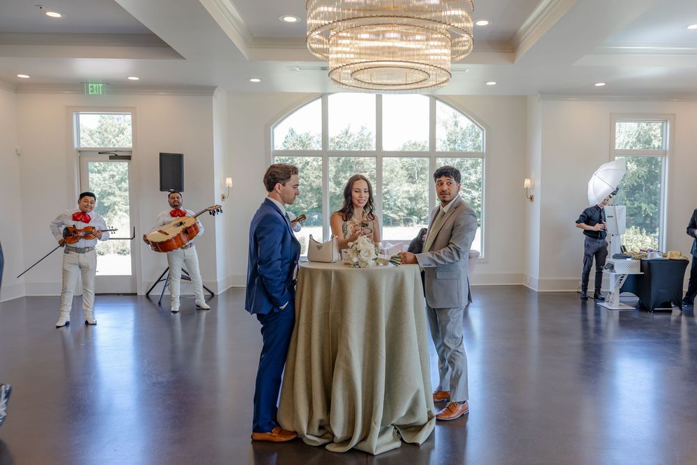 Modern ballroom with circular chandeliers and cocktail tables arranged for an upscale event reception.