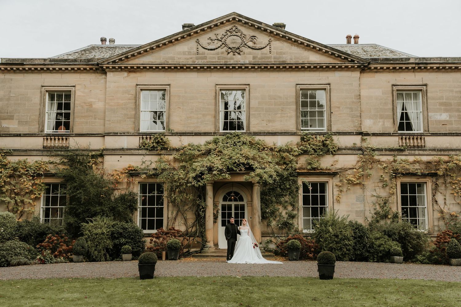 A series of elegant wedding photos taken at a grand historic stone mansion with classic architectural features.