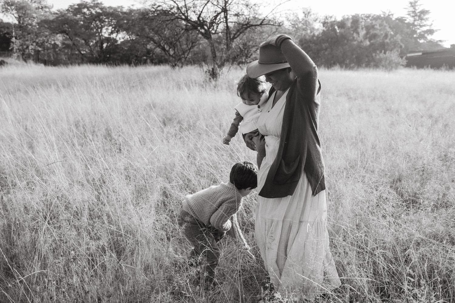 Candid family photos taken in a serene meadow during golden hour.