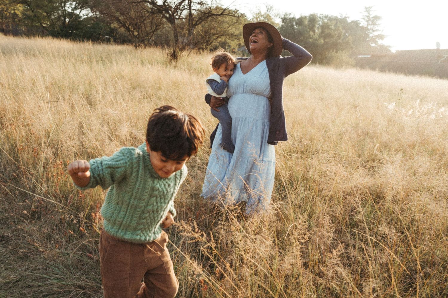 Natural lifestyle photography capturing joyful moments in a wild grass field.