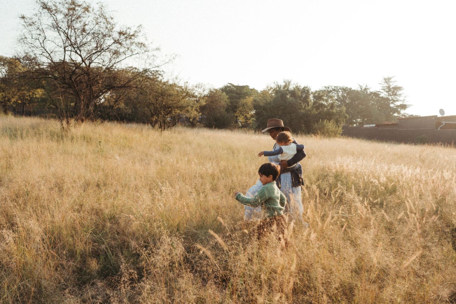 A joyful moment captured in a golden field during sunset with people dancing and twirling.