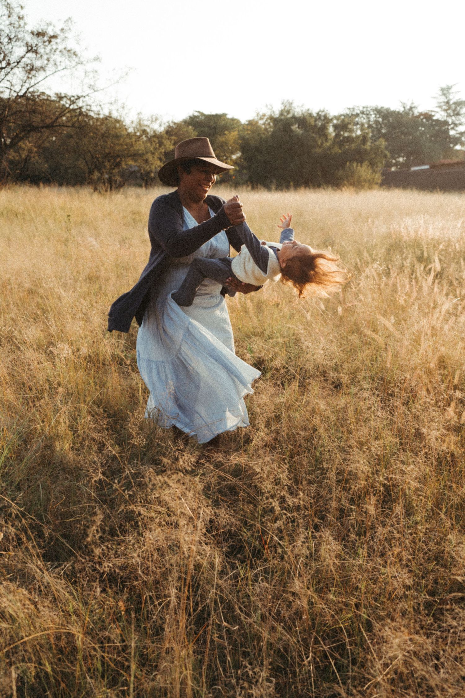 Playful movement captured in a field of golden grass during sunset.