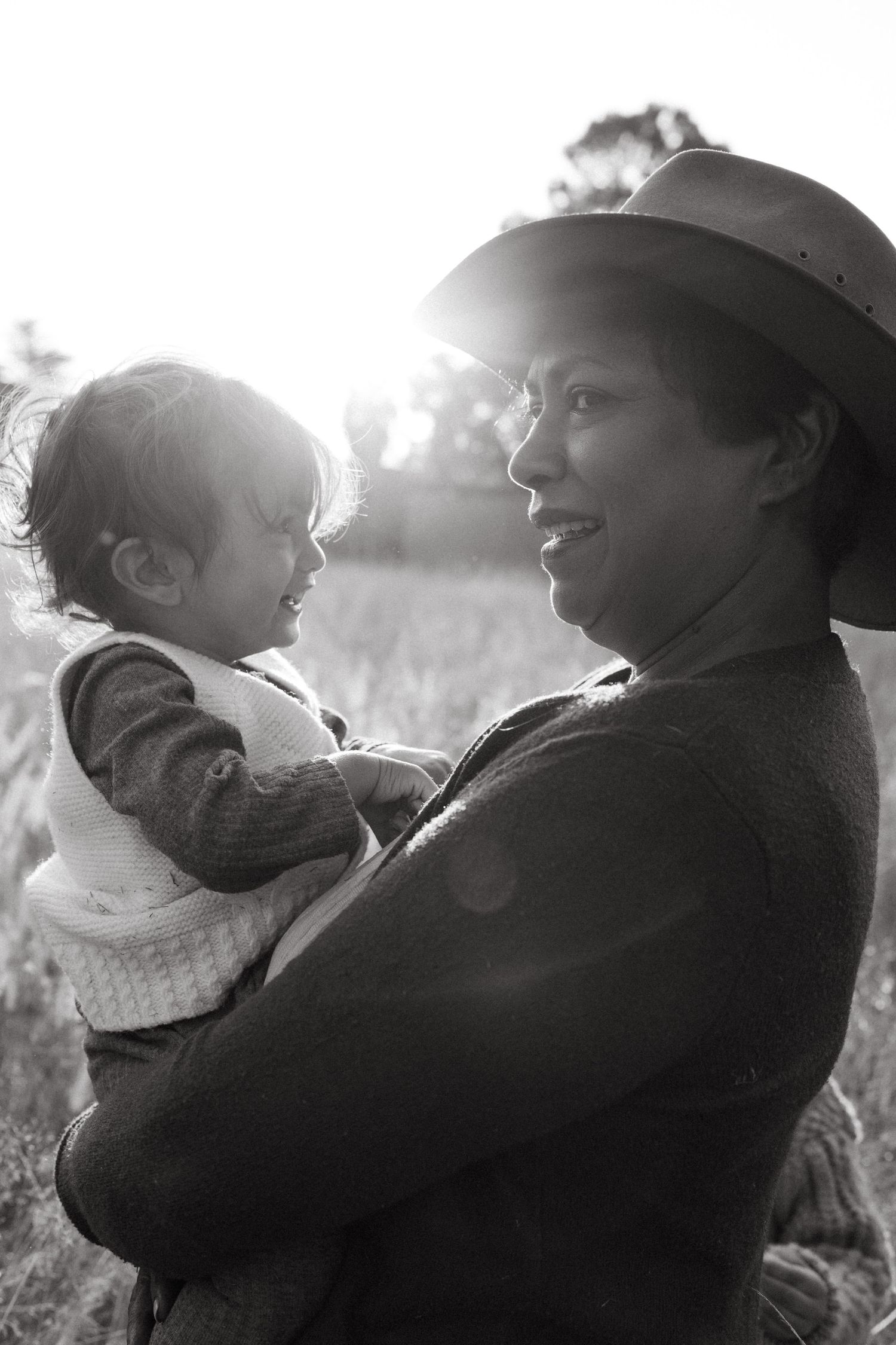 Black and white portrait of two people sharing laughter in natural lighting.