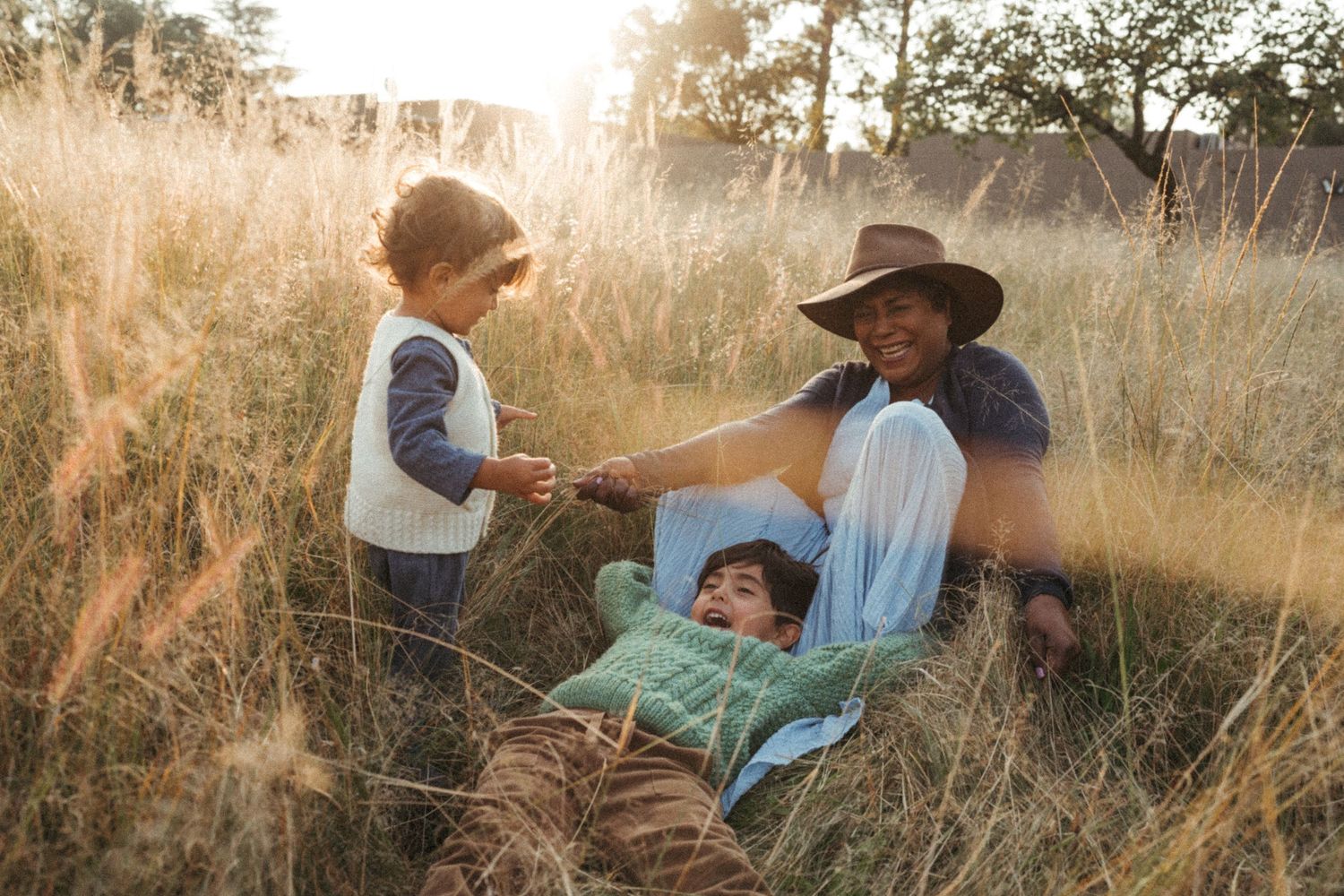 Golden hour photograph showing intimate moments between two people in a field.