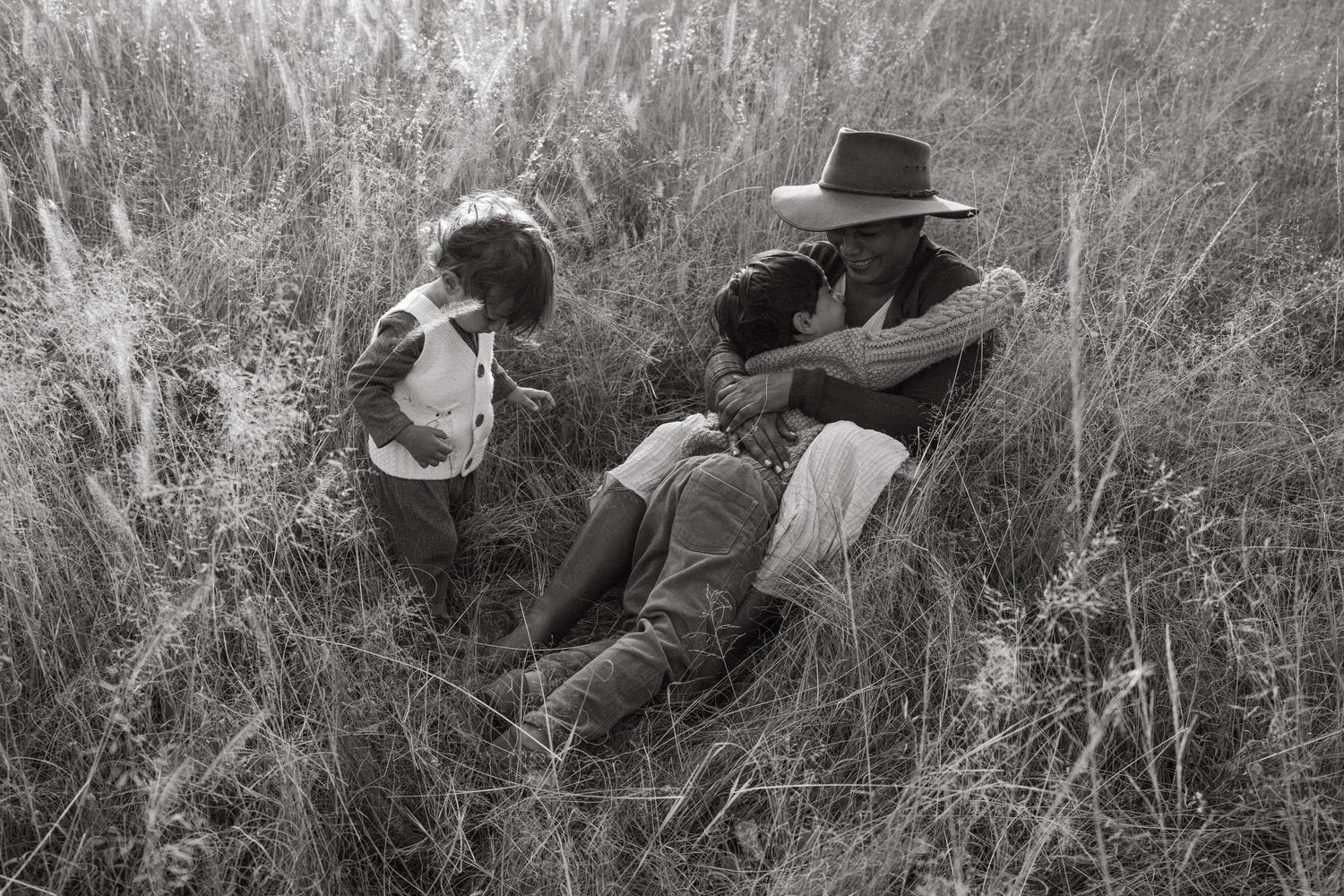 Black and white portrait showing peaceful interaction in a wild grass field.