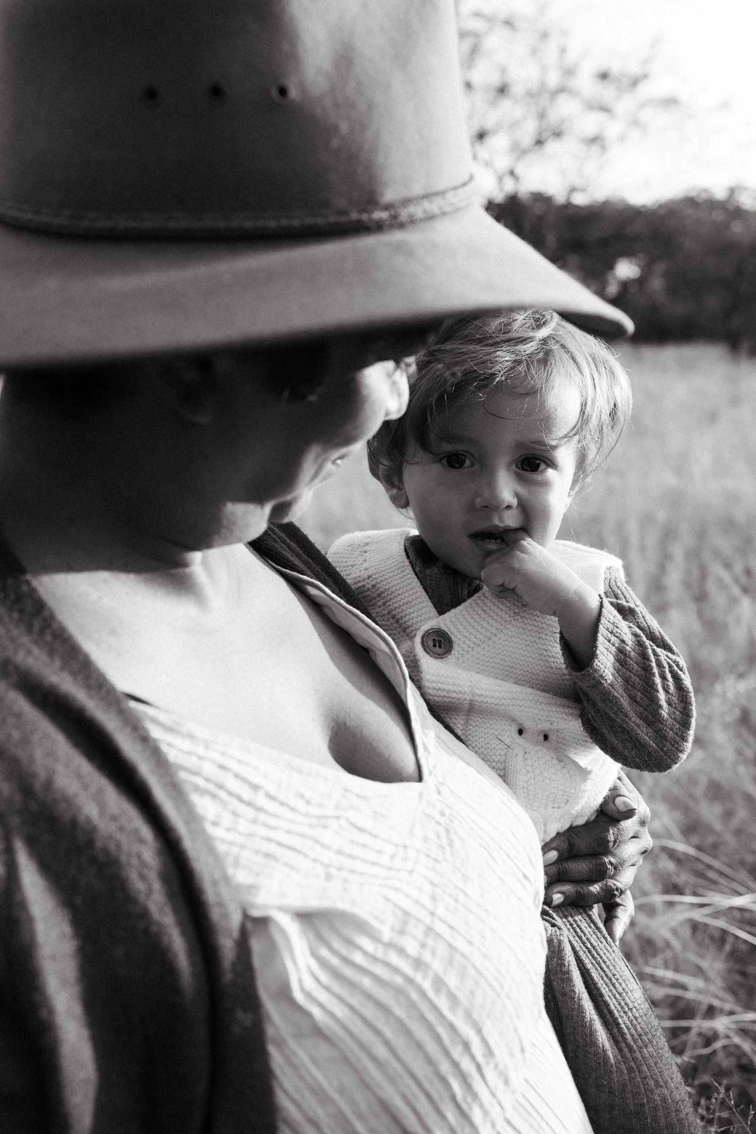 Black and white close-up of tender family moment outdoors.