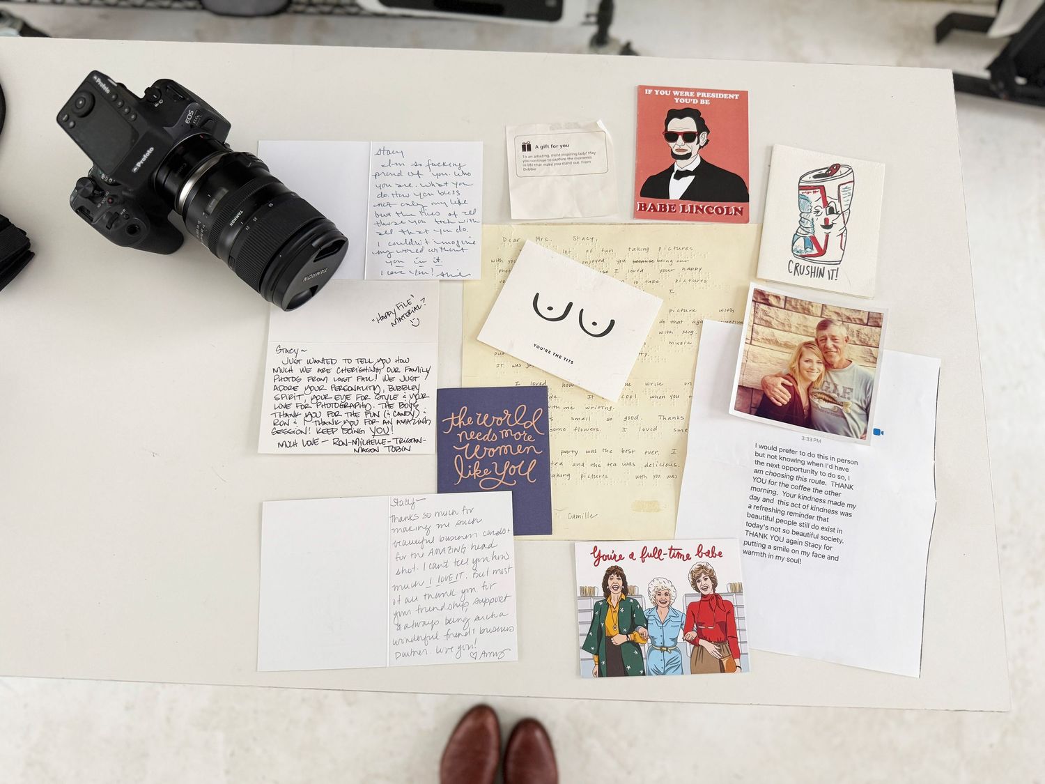 A collection of photographs, handwritten notes, and personal items arranged in a creative layout on a white surface.
