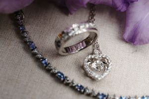 Close-up view of a sparkling diamond engagement ring with delicate purple accents and jewelry details.