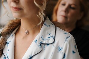 A group of people wearing white and blue butterfly-patterned clothing pose together for a photo.