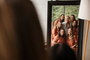 A series of framed photographs showing people in orange outfits displayed on a wall.