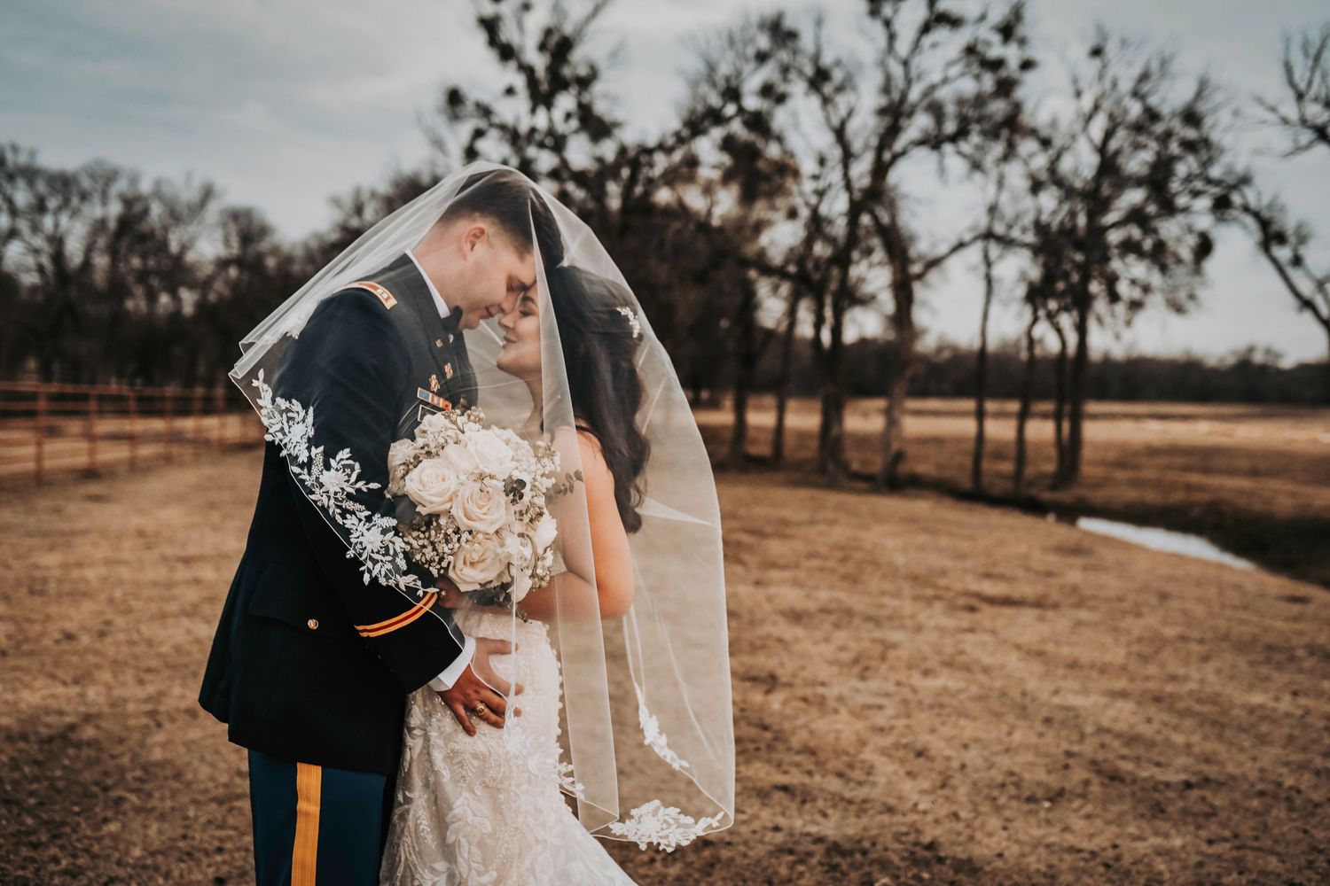 Bride and groom sharing a romantic moment on the open ranch fields at Lucky Spur Ranch.
