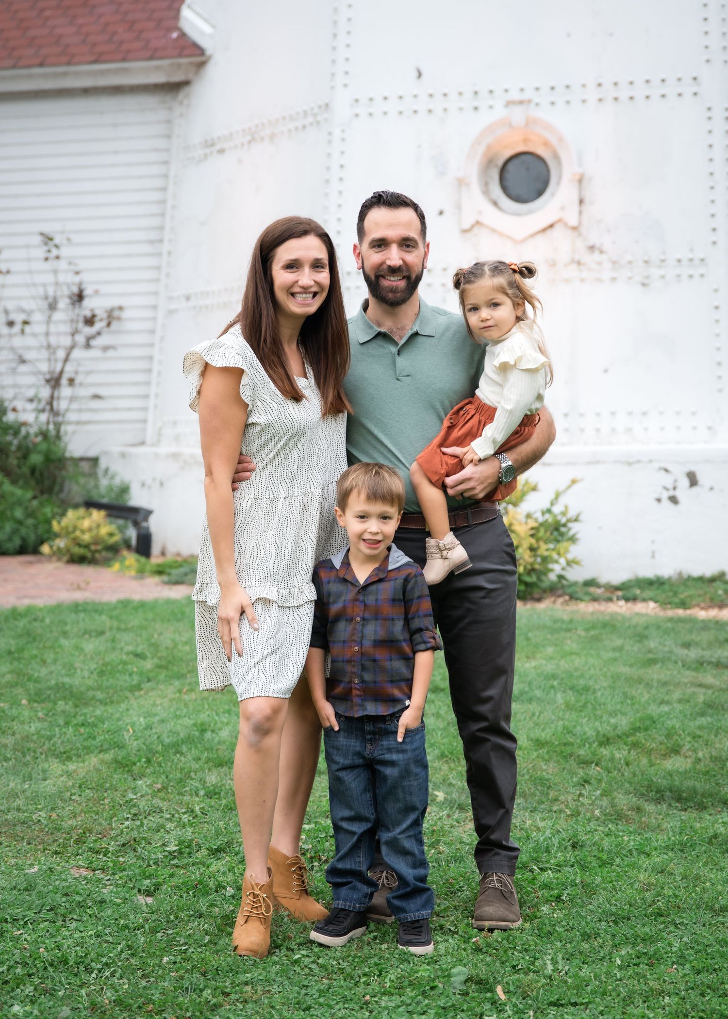 A family poses together on a grassy lawn wearing casual clothing in a series of candid outdoor photos.