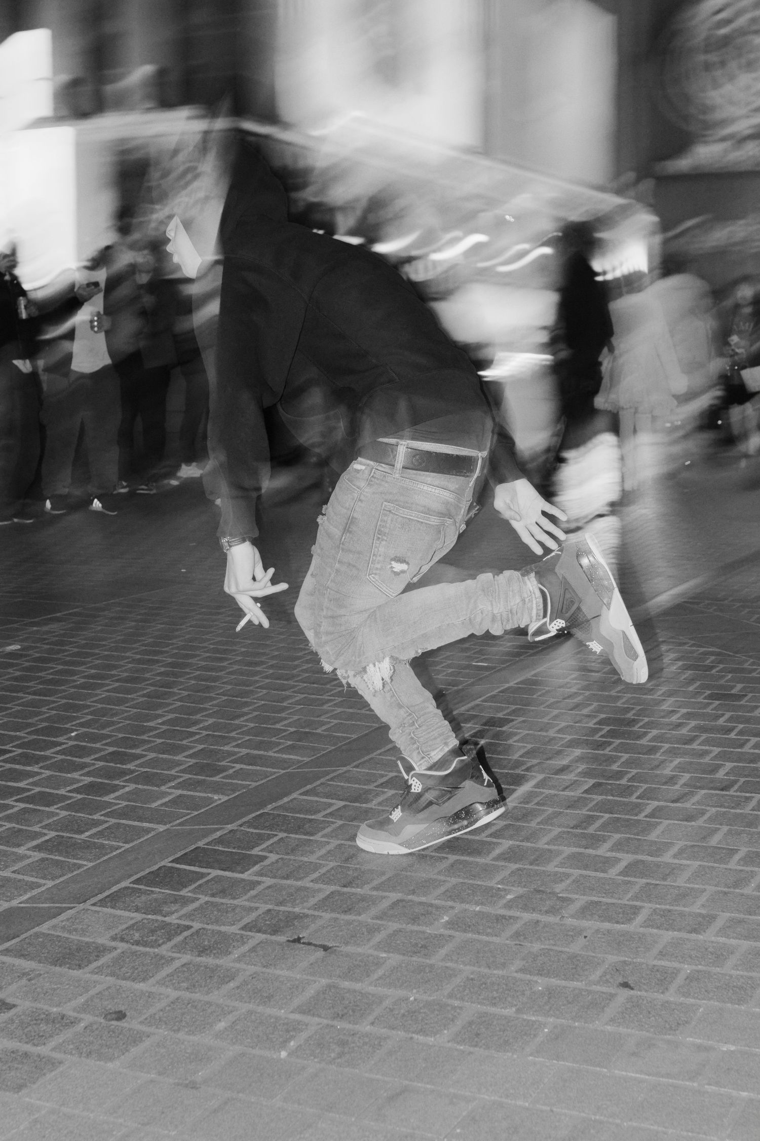 A motion-blurred black and white sequence shows feet dancing on a tiled floor in an energetic display.