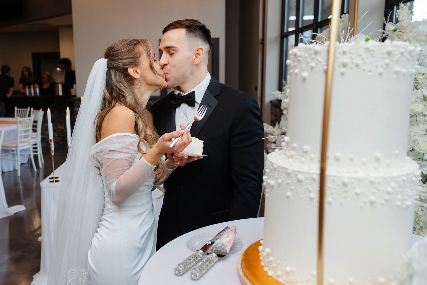 Wedding cake cutting with a kiss at Reserve at Stone Creek in North Canton photographed by Tom Forrest from Hudson, Ohio.