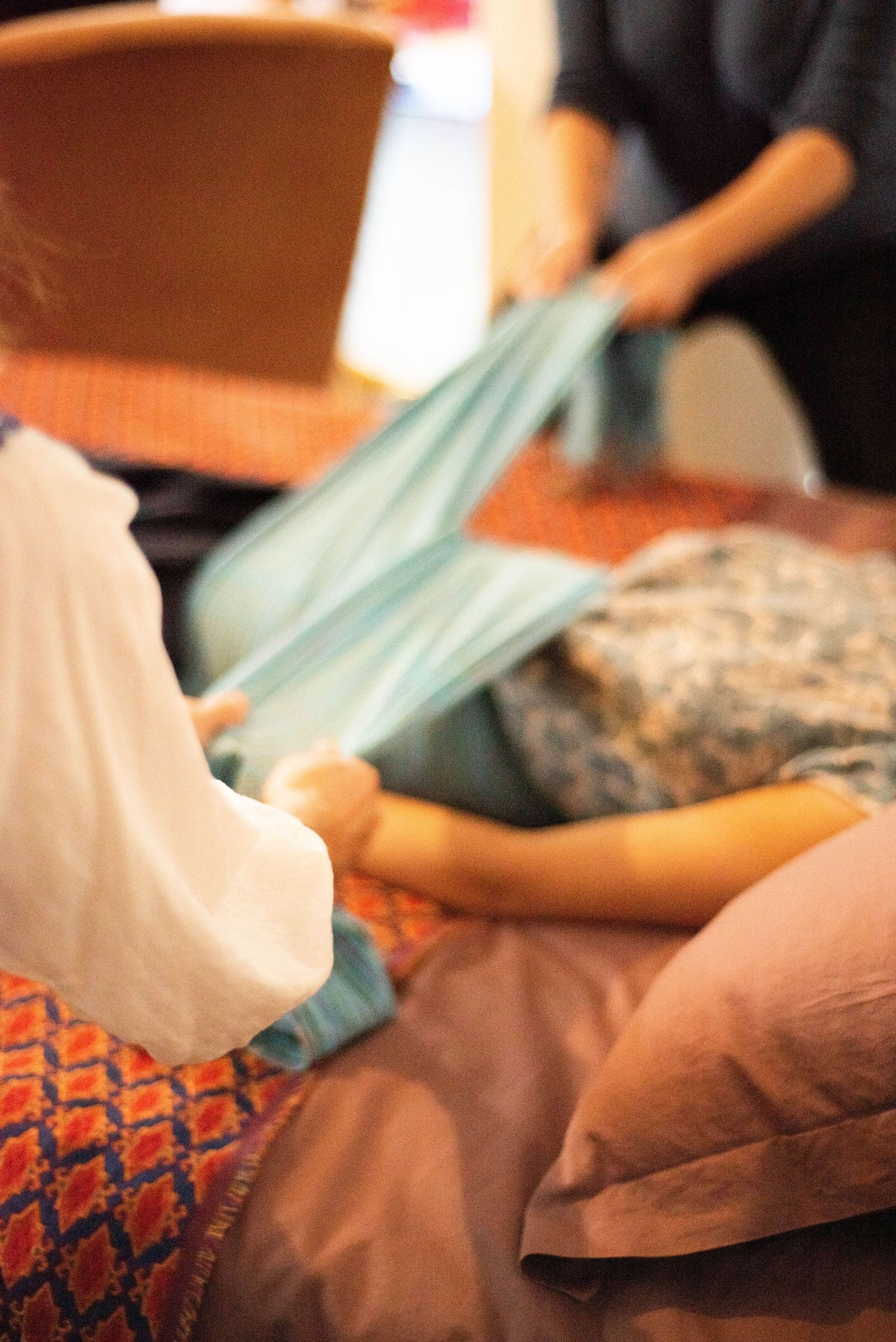 A series of blurred images showing hands giving a therapeutic massage on a table with teal fabric.