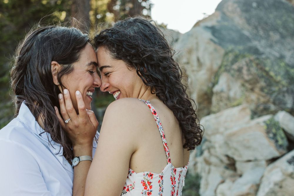 Intimate moment captured between couple against rocky mountain backdrop.