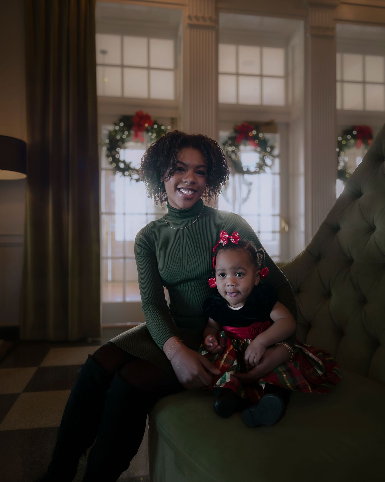 A joyful holiday scene with matching green sweaters and festive decorations in a warmly lit room.