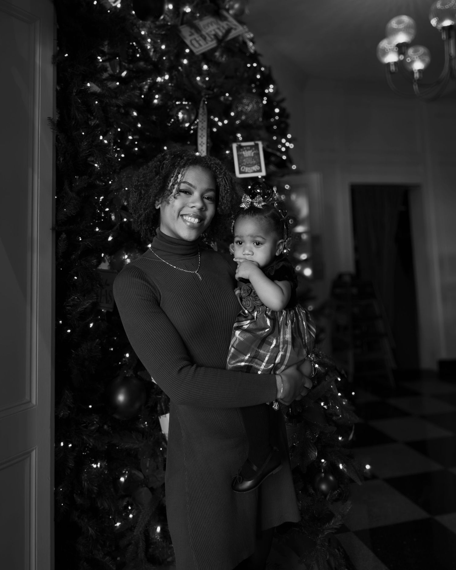 A heartwarming black and white holiday moment captured by a Christmas tree with twinkling lights.