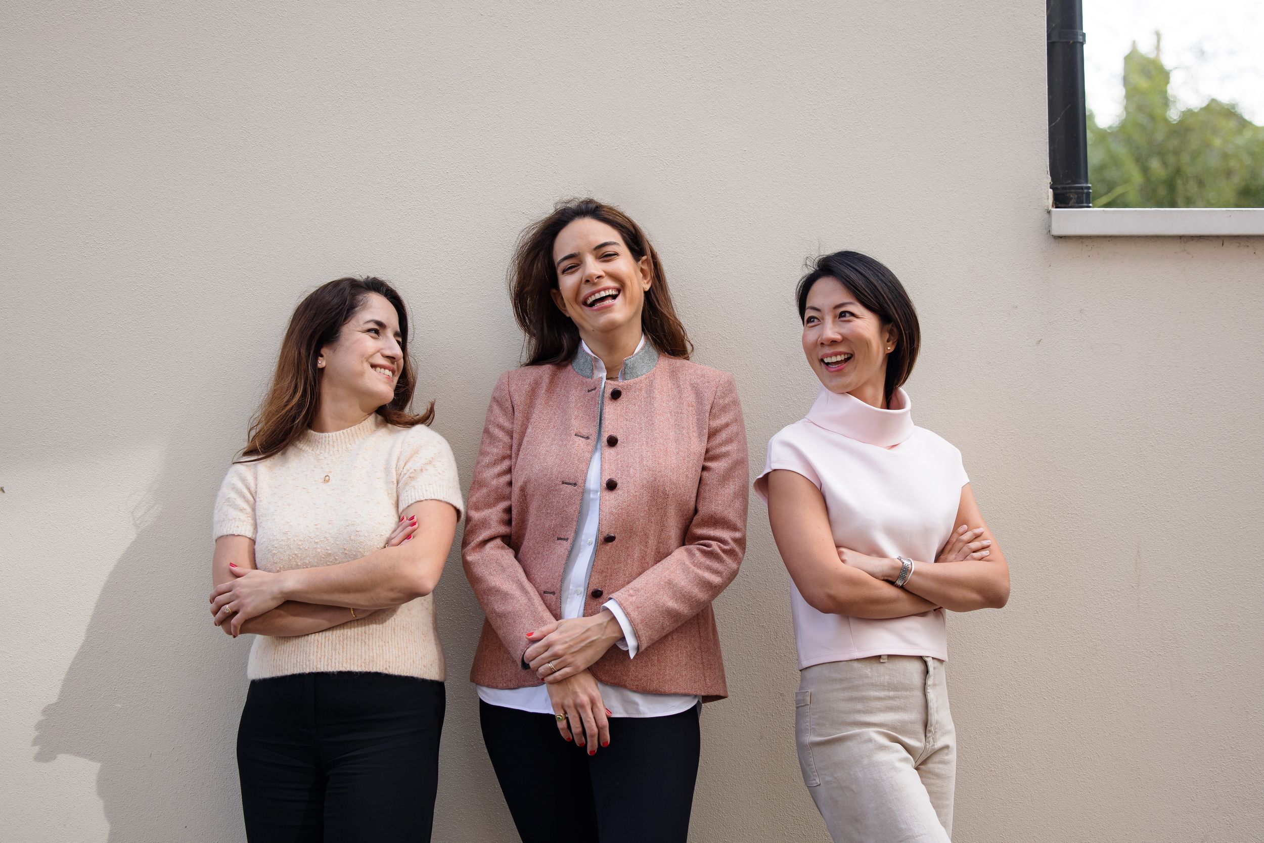 Professional portrait session with women wearing coordinated outfits against a light background.