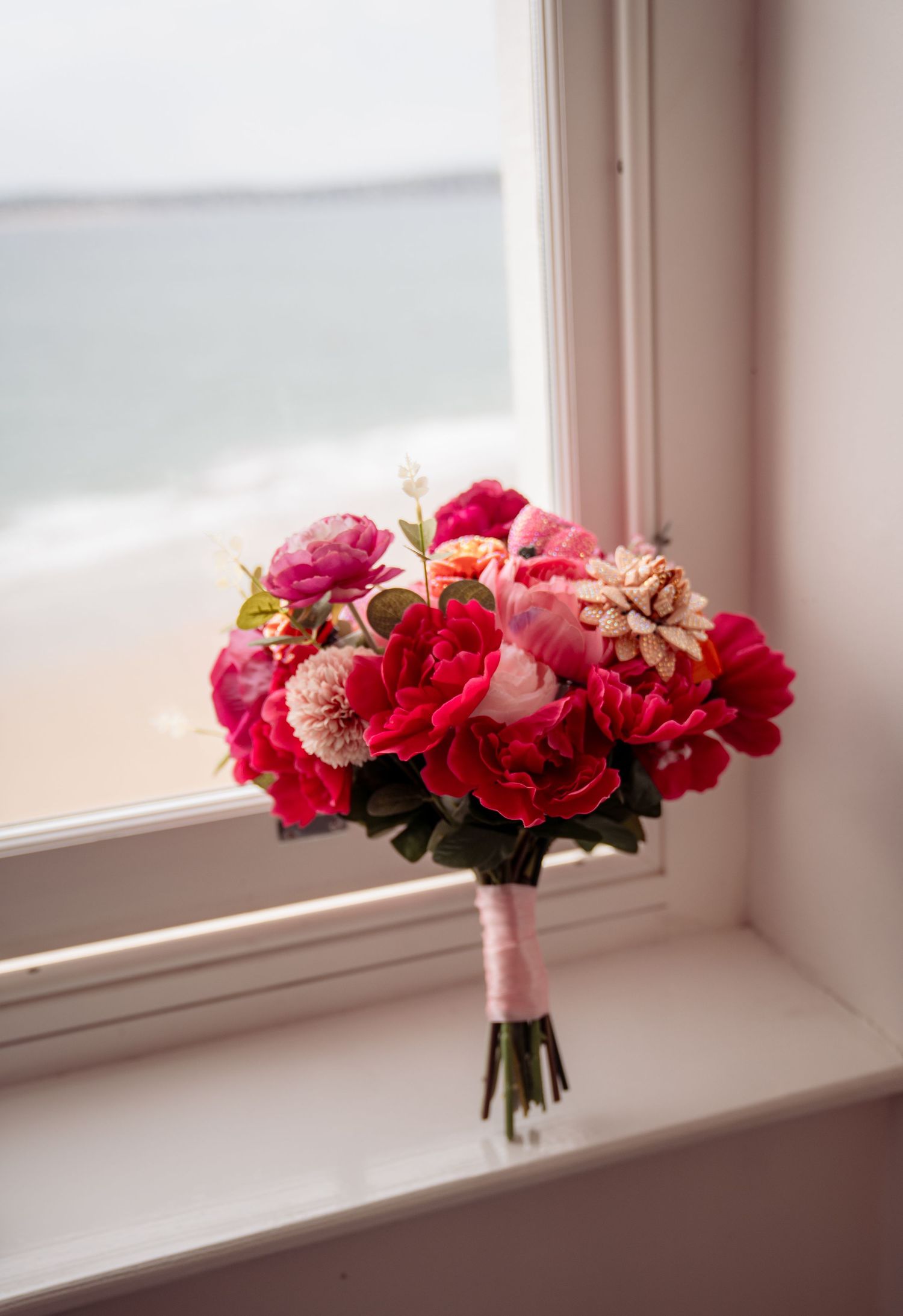 A sequence of four images showing a pink and red floral bouquet on a white windowsill in soft natural light.