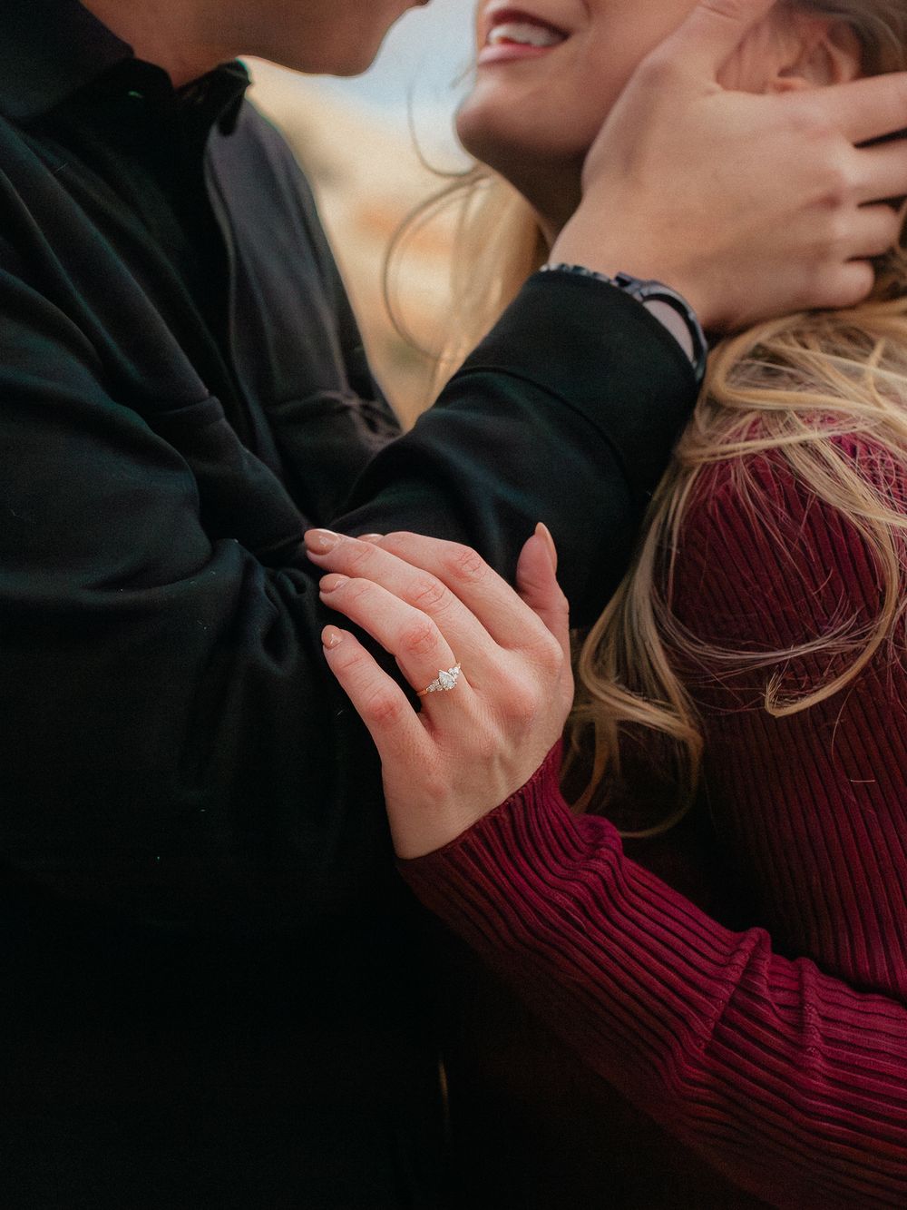 A couple in a romantic embrace wearing black and burgundy sweaters share intimate moments in a photo series.