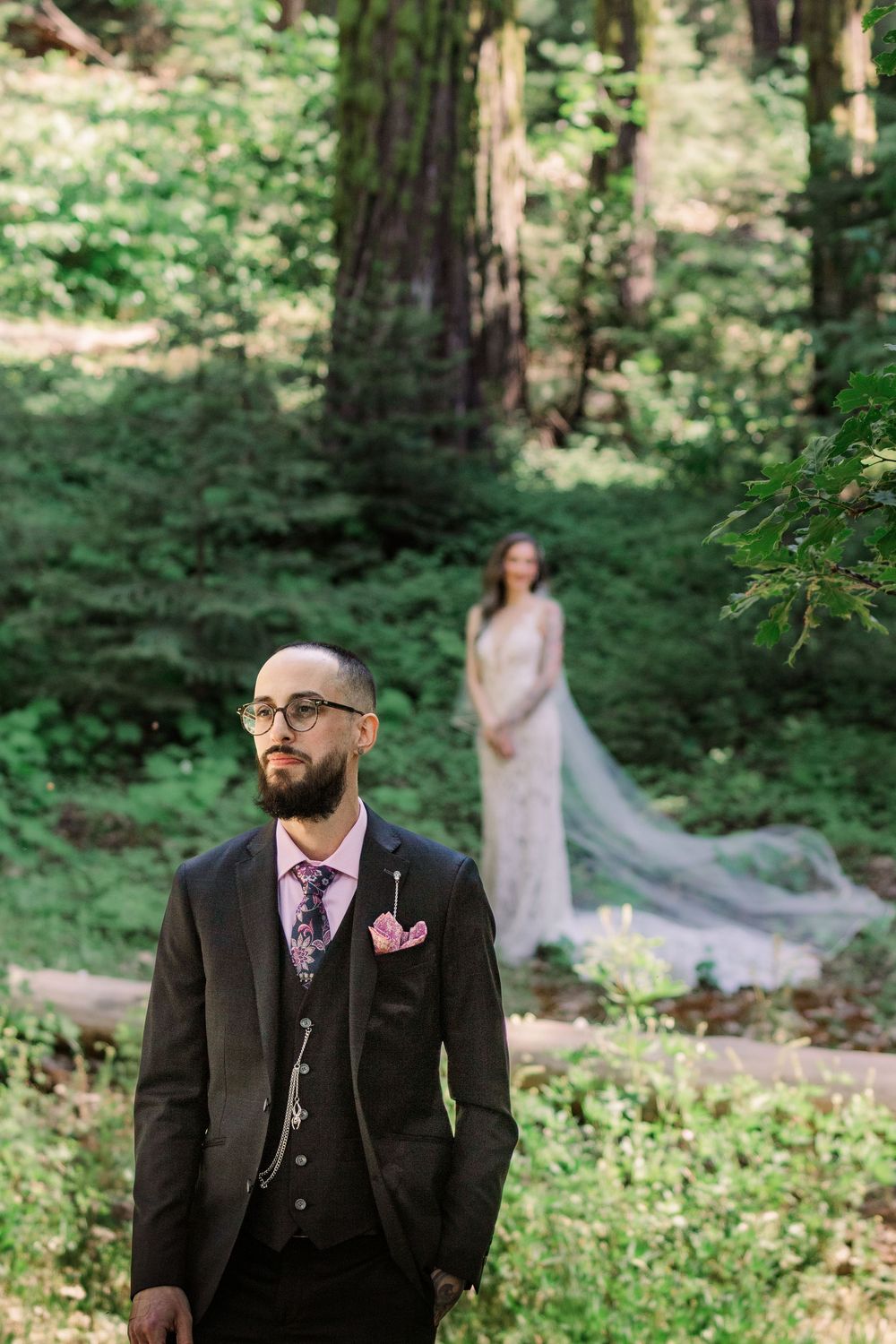 Wedding first look moment captured in lush forest setting.