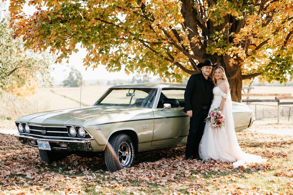 Classic silver Chevrolet El Camino parked under autumn tree with golden leaves on a sunny fall day.
