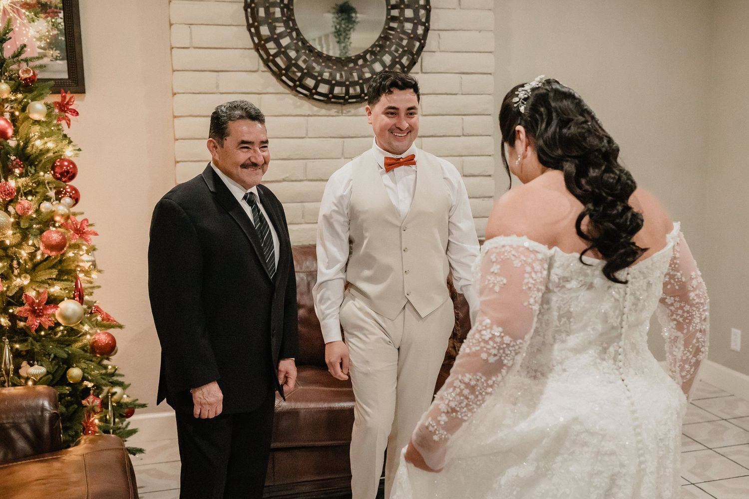 Wedding party members gather near a decorated Christmas tree during a winter ceremony.
