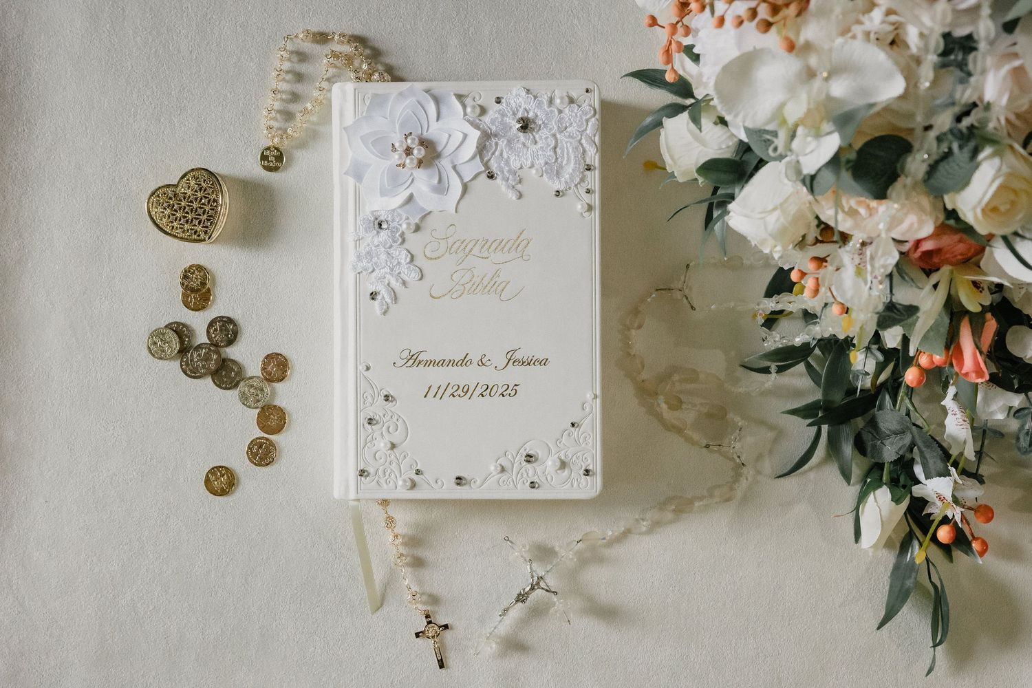 Elegant wedding details with invitation cards, rings, and delicate floral arrangements on light background.