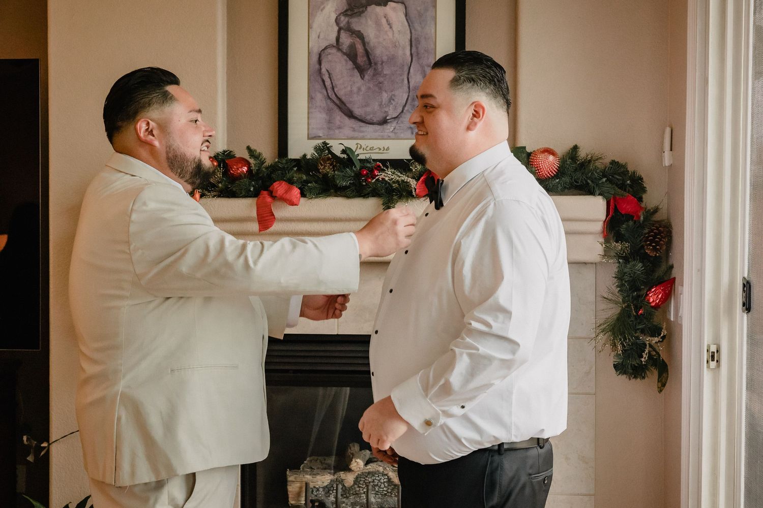 Two people in formal attire prepare for a special event in an elegant indoor setting.