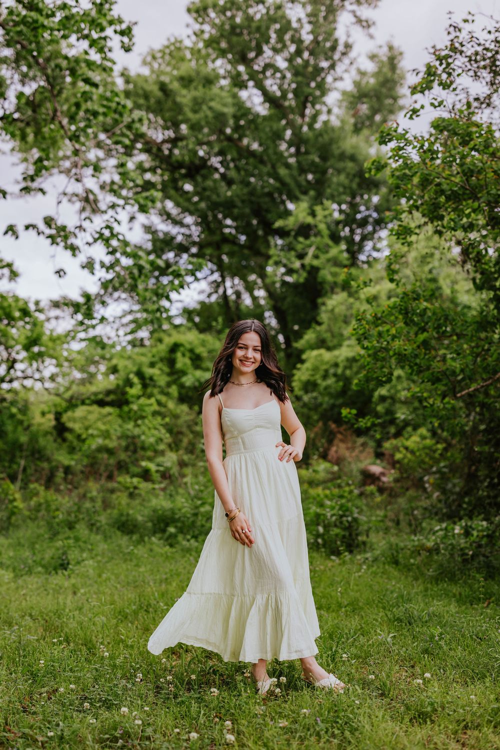 A flowing white sundress catches the sunlight in a verdant garden setting with wildflowers.