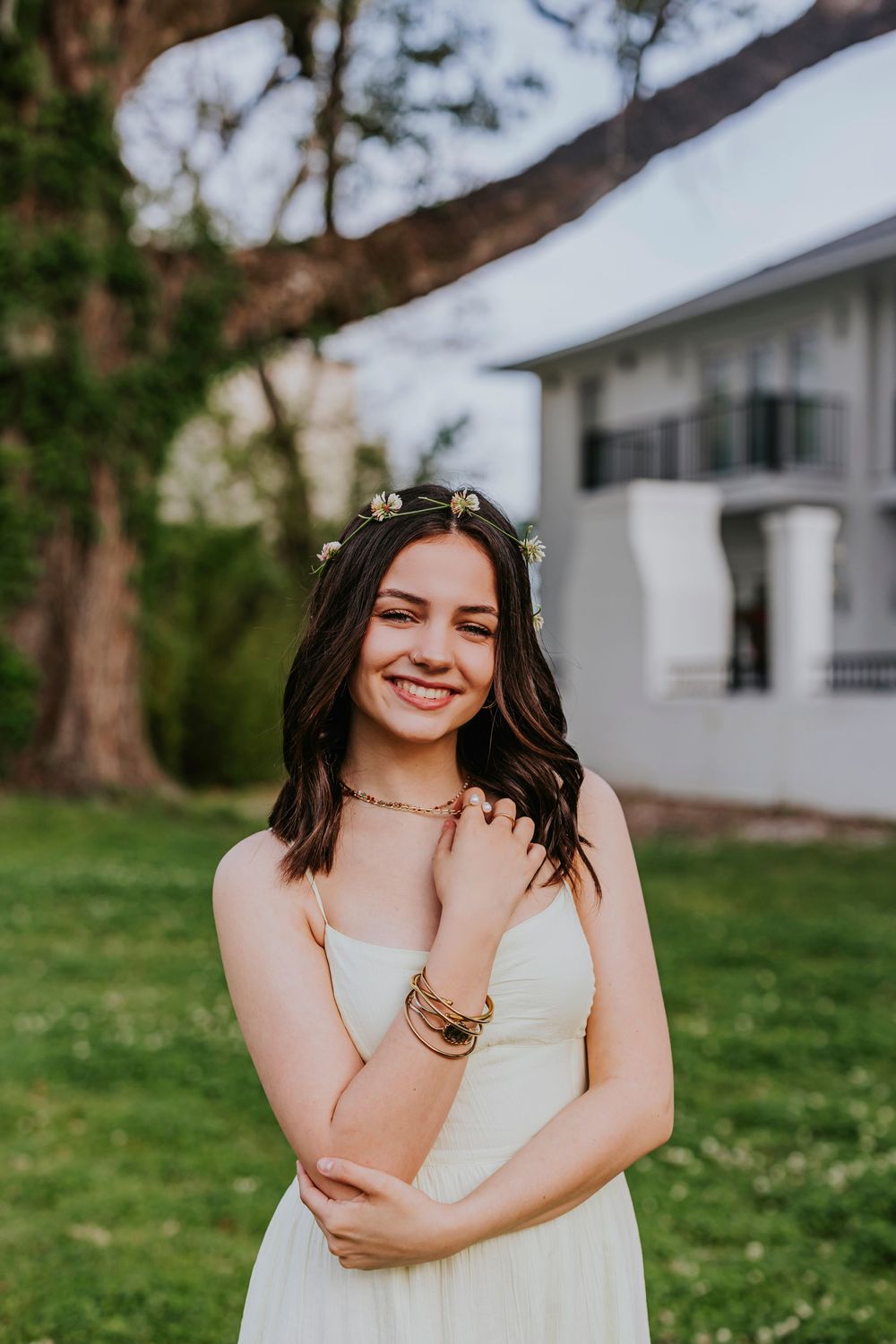 Joyful outdoor portrait session featuring a white dress and natural expressions against green grass.