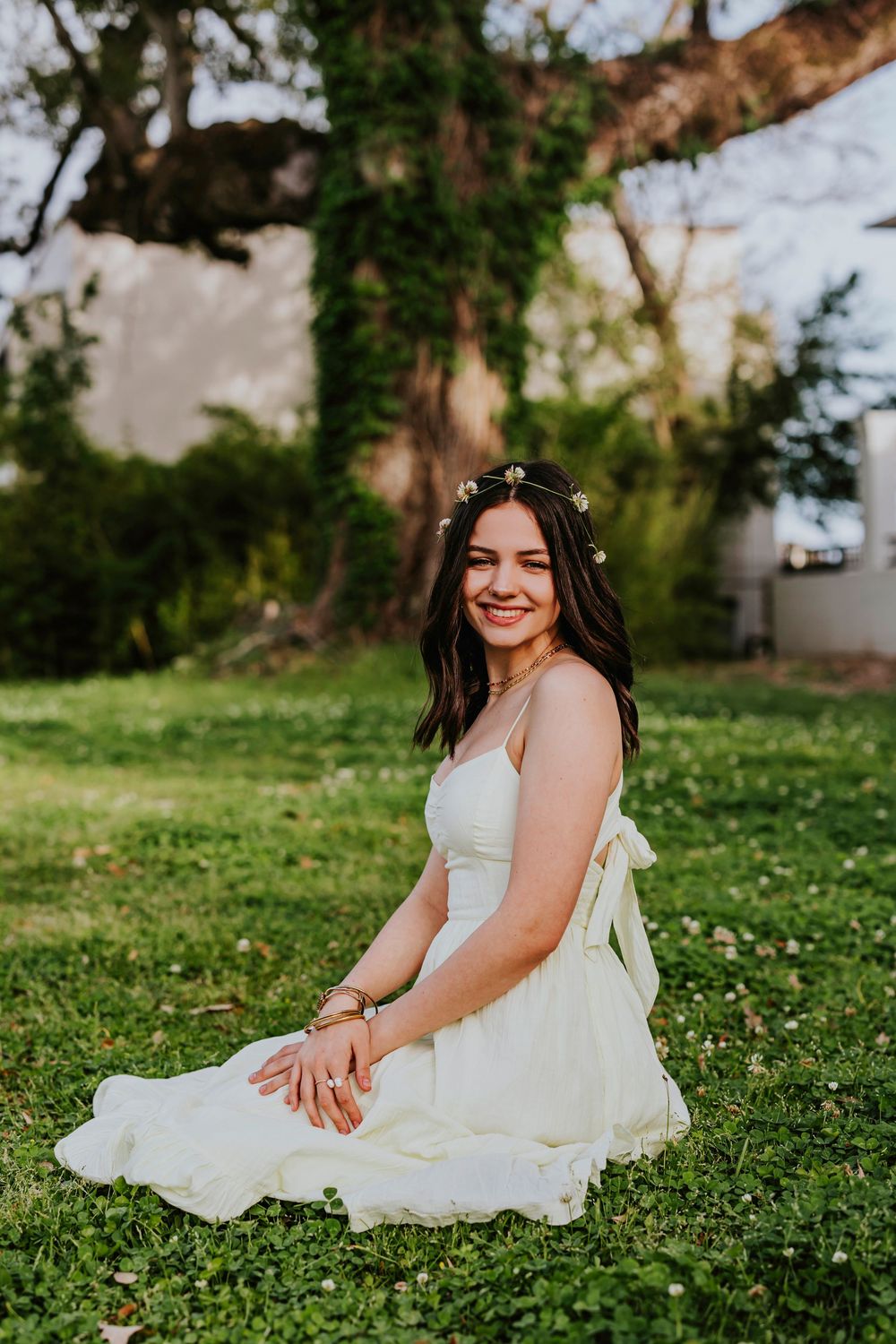 Candid moments captured on a grassy lawn with delicate spring flowers and white architecture.