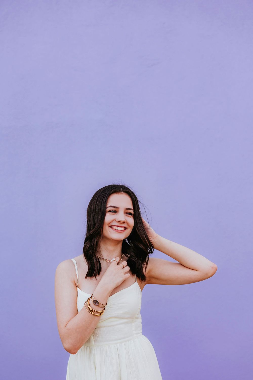 Expressive portraits against a soft purple wall showcasing natural movement and joy.