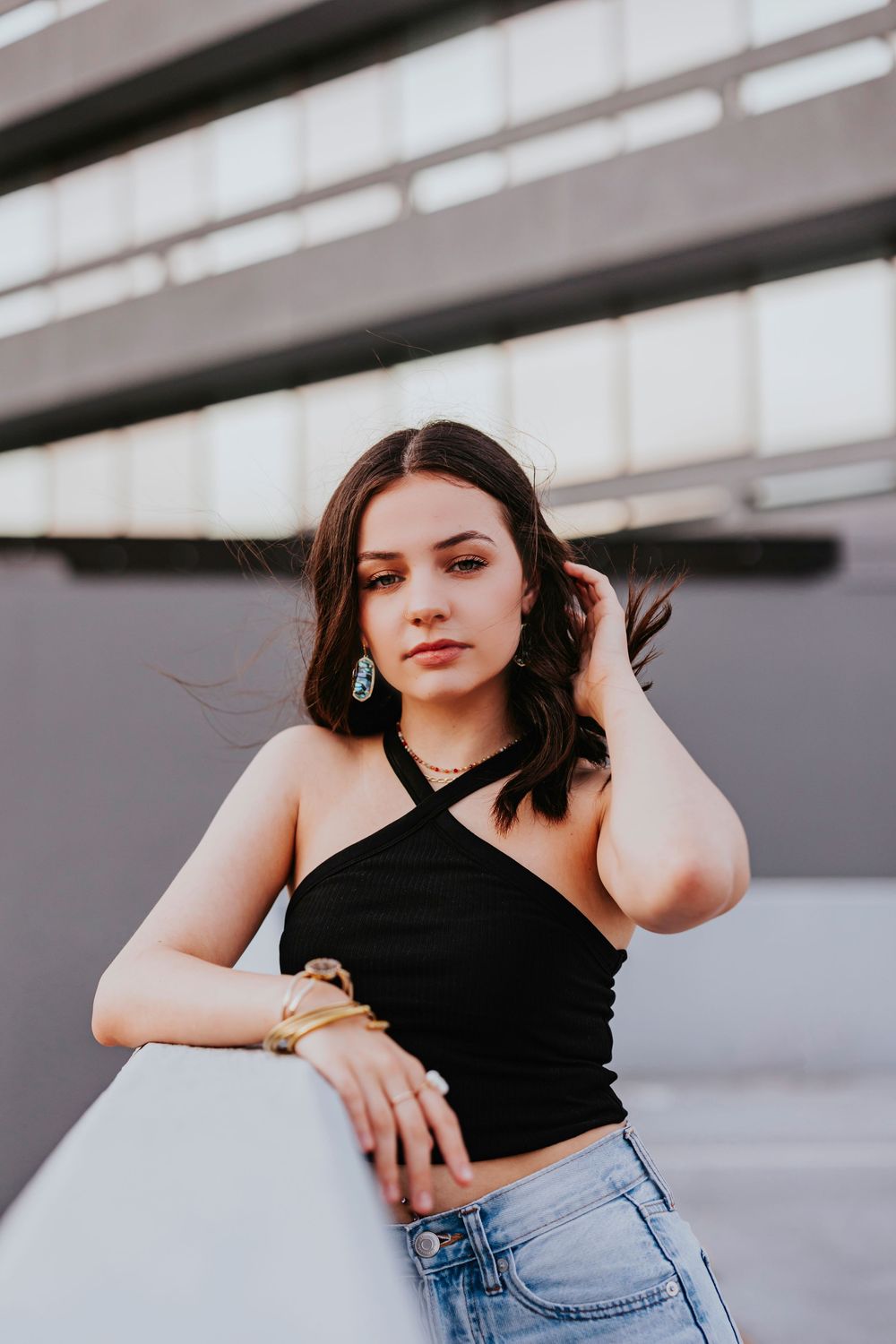 Urban fashion photoshoot featuring casual style against concrete architecture.