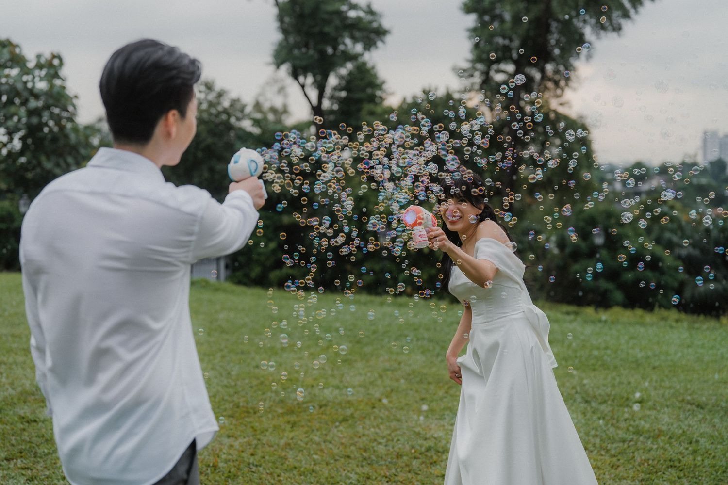 A couple having fun with confetti in an outdoor wedding photoshoot.